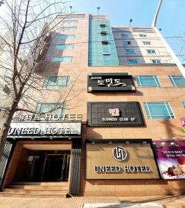 een gebouw met borden aan de zijkant bij Uneed Hotel in Daegu