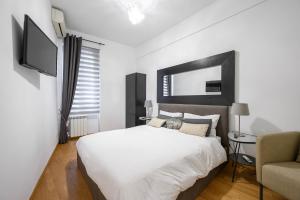 ローマにあるNavona & Pantheon Cozy Apartmentの白いベッドルーム(ベッド1台、椅子付)