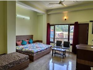 Un dormitorio con una cama y una mesa y una ventana. en Hill View Regency BEST BUDGET HOTEL NEAR MALL ROAD, en Shimla