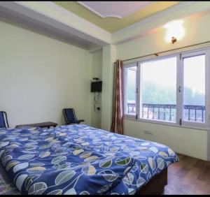 Un dormitorio con una cama y una ventana grande. en Hill View Regency BEST BUDGET HOTEL NEAR MALL ROAD, en Shimla