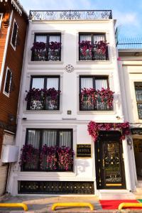 een wit gebouw met bloemen in de ramen bij Little sofia hotel in Istanbul