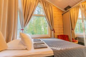 a bedroom with a bed and a large window at Saimaa Life Apartments in Imatra
