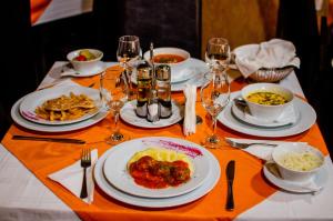 Hotel Davos في ديفا: طاولة مليئة بأطباق الطعام وكؤوس النبيذ