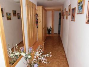 a hallway with flowers on the floor and a mirror at Haus Wegscheider in Teisendorf