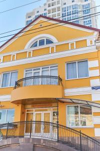 a yellow building with a balcony and some buildings at Like хостел Саратов in Saratov