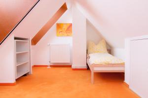 a attic room with a bed and a book shelf at Naturidyll auf Rügen in Putbus