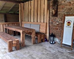 a patio with two wooden benches and a sign at Dworek Szarki in Szarki