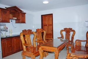a kitchen with a wooden table and chairs and a table and a counter at 5H homestay & Motorbikes For Rent in Hue