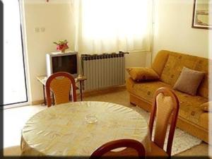 a living room with a table and a couch at Apartment in Kampor with sea view, terrace, air conditioning, Wi-Fi (4610-2) in Kampor