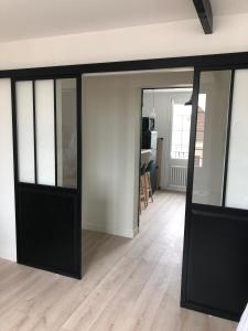 a room with black sliding doors and a living room at Bel appartement plein centre 100m de la mer in Merville-Franceville-Plage