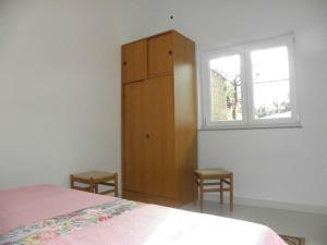 ein Schlafzimmer mit einem Bett, einer Kommode und einem Fenster in der Unterkunft Apartment in Duce with Terrace, Air conditioning, Wi-Fi, Washing machine (4166-6) in Duće