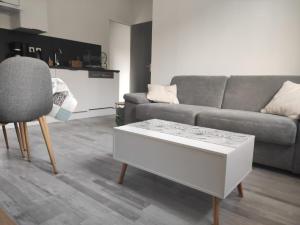 a living room with a couch and a coffee table at L'Appartement du Veillon in Talmont