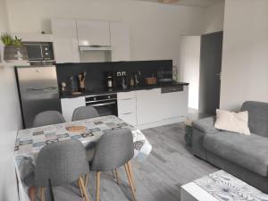 a kitchen and living room with a table and chairs at L'Appartement du Veillon in Talmont