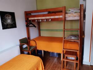 1 Schlafzimmer mit 2 Etagenbetten und einem Stuhl in der Unterkunft Gite "Etape à Coucy" in Coucy-le-Château-Auffrique