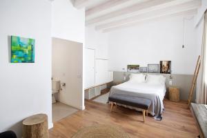 1 dormitorio con cama blanca y suelo de madera en Mon hotel en Ciutadella