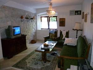 a living room with a couch and a tv at Apartment in Zlarin with balcony, W-LAN, washing machine (3813-2) in Zlarin