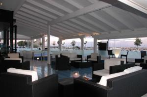 サン・フォカにあるホテル コート デストの白いテーブルと椅子が並ぶレストラン