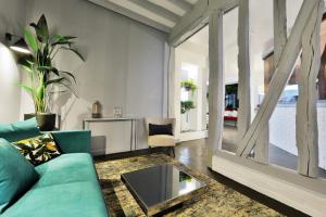 a living room with a blue couch and a table at Logis Hôtel & Restaurant du Sauvage in La Ferté-Gaucher