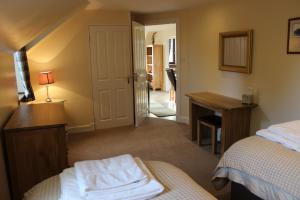 a bedroom with two beds and a desk and a mirror at Ness View Apartment in Inverness