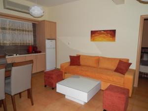 a living room with a couch and a kitchen at Sofia Apartments in Sivota