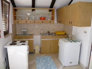 a small kitchen with a stove and a refrigerator at Apartment in Zlarin with balcony, W-LAN, washing machine (3813-1) in Zlarin