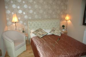1 dormitorio con 1 cama y 1 silla en Guest House Maja, en Novi Sad
