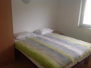 a bed with two pillows sitting in a bedroom at Apartments Baba Luce in Strica