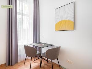 uma sala de jantar com uma mesa e duas cadeiras em Apartment Berlin Paul-Robeson-Straße em Berlim