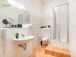 a white bathroom with a sink and a toilet at Apartment Berlin Paul-Robeson-Straße in Berlin