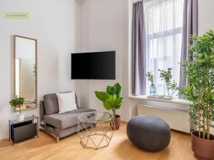 uma sala de estar com plantas, uma cadeira e um espelho em Apartment Berlin Paul-Robeson-Straße em Berlim