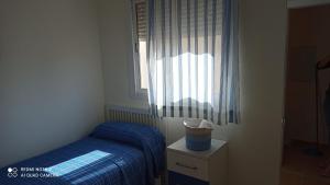 ein kleines Schlafzimmer mit einem Bett und einem Fenster in der Unterkunft Apartamento en rota in Rota