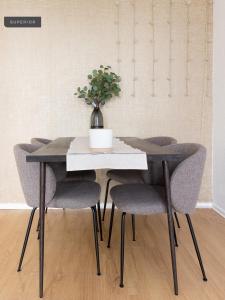 a table with chairs and a vase with a plant on it at Apartments Berlin Niederbarnimstraße in Berlin