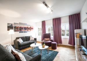 ein Wohnzimmer mit einem Sofa und einem Tisch in der Unterkunft Familienapartment mit Blick zur Frauenkirche in Dresden