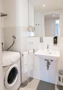 a white bathroom with a washing machine and a sink at Familienapartment mit Blick zur Frauenkirche in Dresden