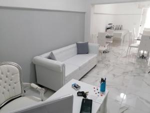 a white living room with a white couch and chairs at B&B WHITE HOUSE in Pulsano