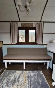 a bench in a room with a bed and a window at TORRHEBİA DAĞ EVİ in Odemis