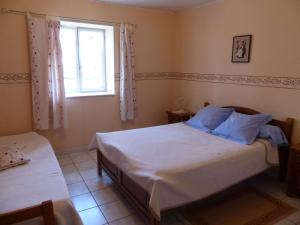 a bedroom with a white bed and a window at le Chaumois in Saint-Boil