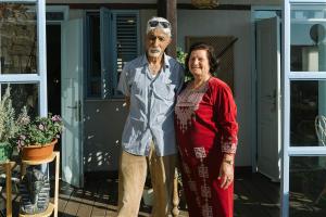 an older man and woman standing on a porch at Saint Anna Akko in ‘Akko