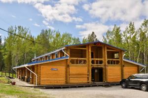 a log cabin with a car parked in front of it at Motel Gora Krestovaya in Kandalaksha