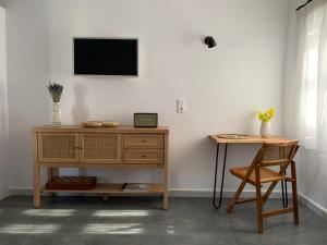 a room with a desk and a television on a wall at Statheros Garden in Andiparos
