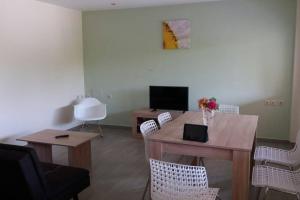 uma sala de estar com uma mesa e cadeiras e uma televisão em Nafsika House Benitses em Benitses