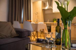 un tavolo con una bottiglia di vino e due bicchieri di vino di Apartment Navis a Dubrovnik