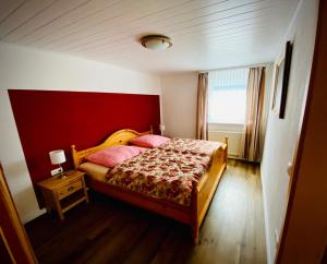 1 dormitorio con 1 cama con pared roja en Gästehaus Lang, en Wunsiedel