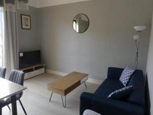 - un salon avec un canapé bleu et une table dans l'établissement BEL APPARTEMENT TYPE F3, à Amélie-les-Bains-Palalda