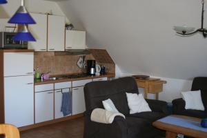 a living room with a couch and a kitchen at Ferienwohnung-SonnenMeer in Neuharlingersiel