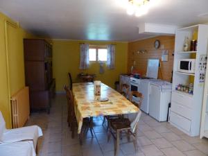 a kitchen with a table and a kitchen with a refrigerator at le Chaumois in Saint-Boil