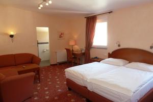 ein Hotelzimmer mit einem Bett und einem Stuhl in der Unterkunft AKZENT Hotel Berg's Alte Bauernschänke- Wellness und Wein in Rüdesheim am Rhein
