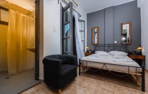 a bedroom with a bed and a chair at Villa Toula in Fira