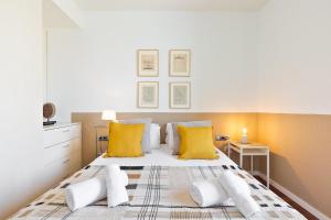 a bedroom with a large bed with yellow pillows at Ola Living Plaza Catalunya in Barcelona