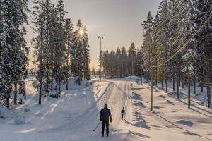 dos personas de esquí de fondo por una carretera cubierta de nieve en Saimaa Life Apartments, en Imatra